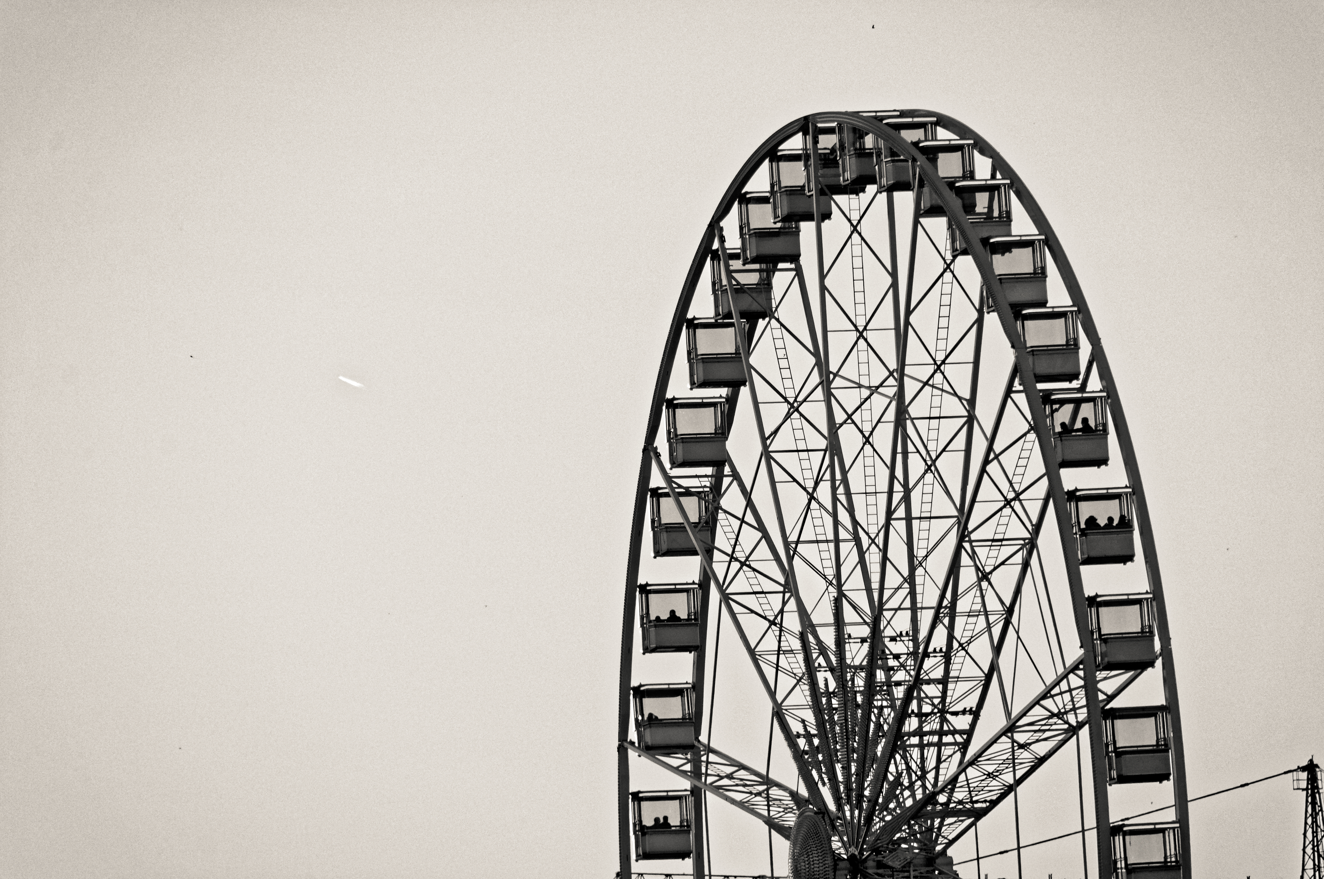Ferris wheel silhouette against an overcast sky