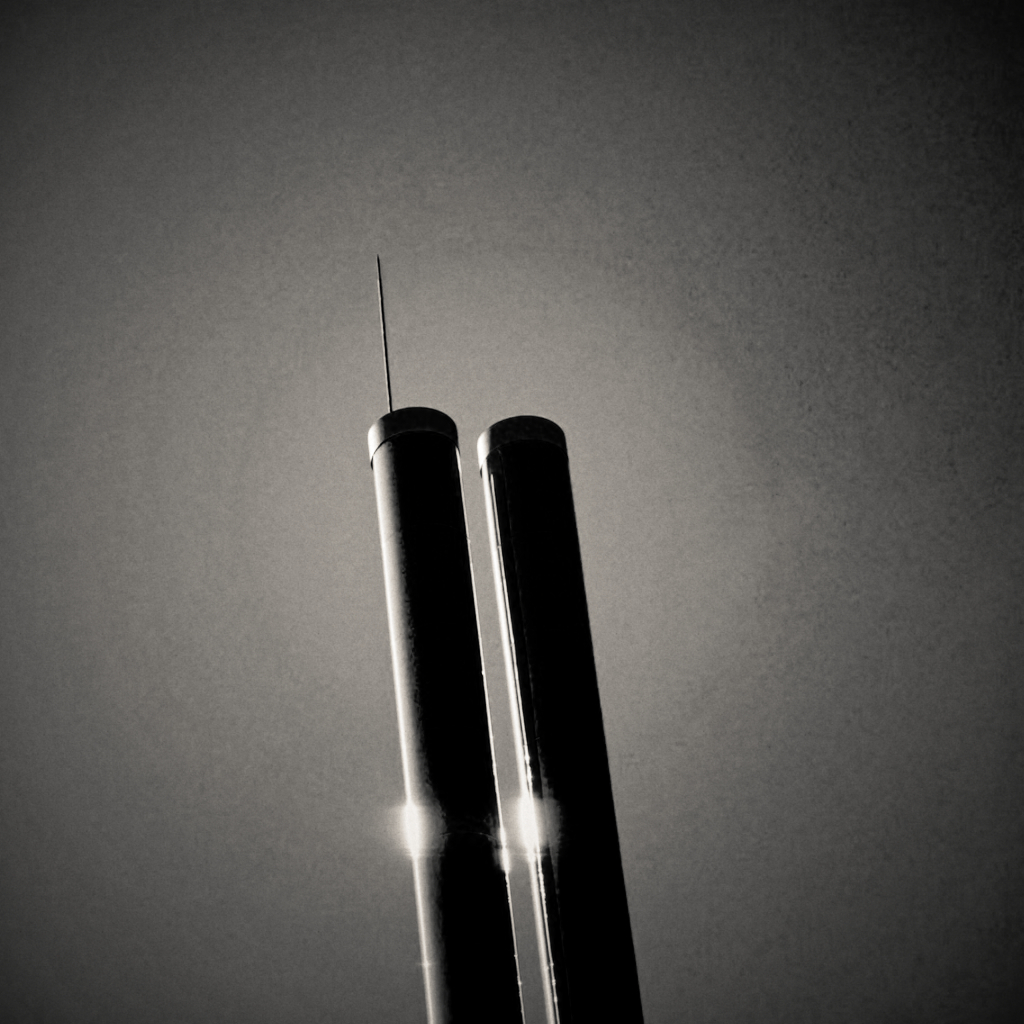 Two industrial chimneys silhouetted against a backlit sky